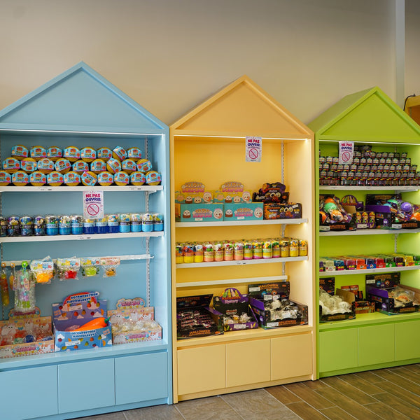 Étagères en forme de maisons bleue, jaune et verte remplies de jouets